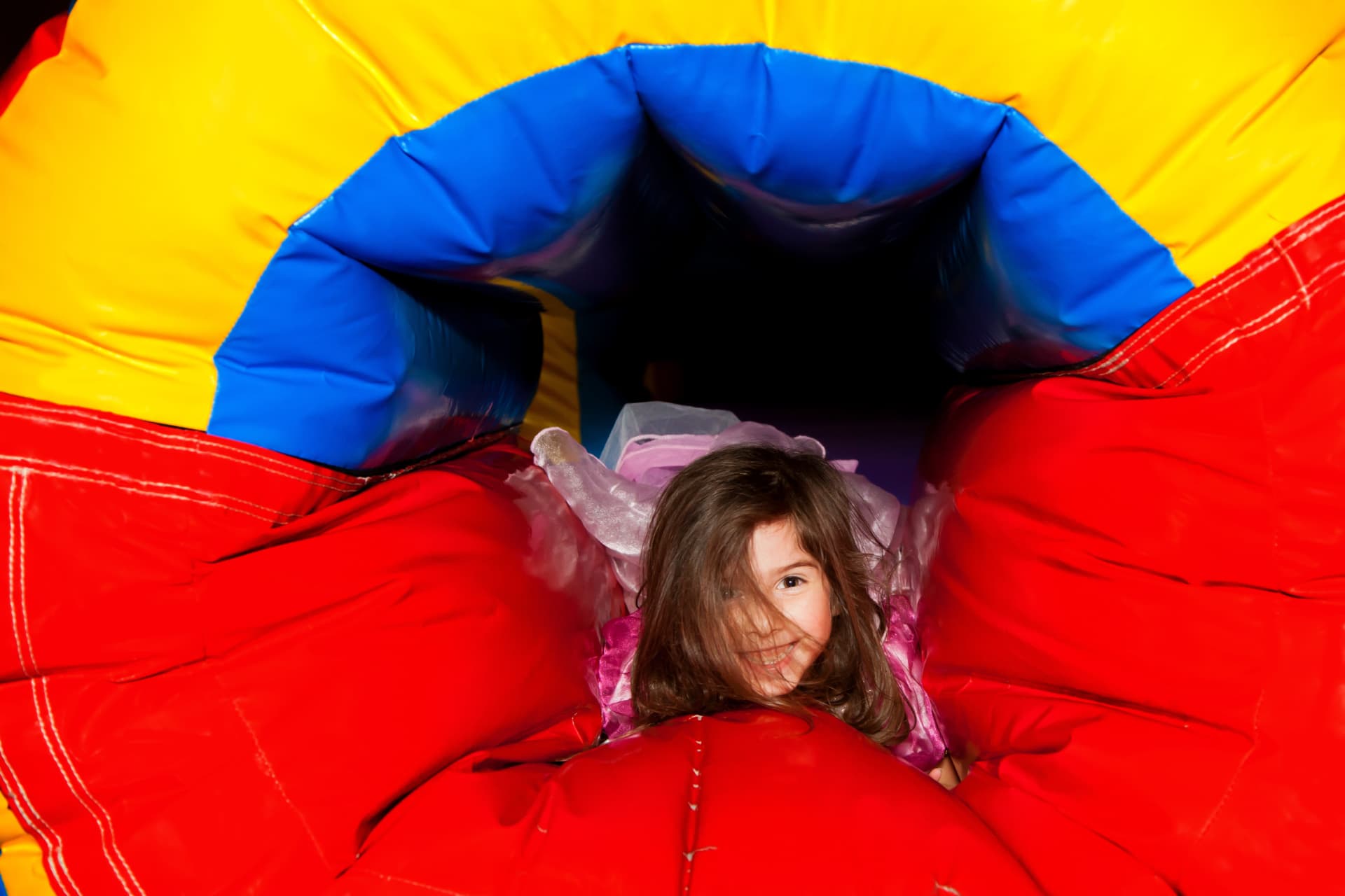Children playing inside a colorful inflatable tunnel — party rental delivered in Cape Coral, FL